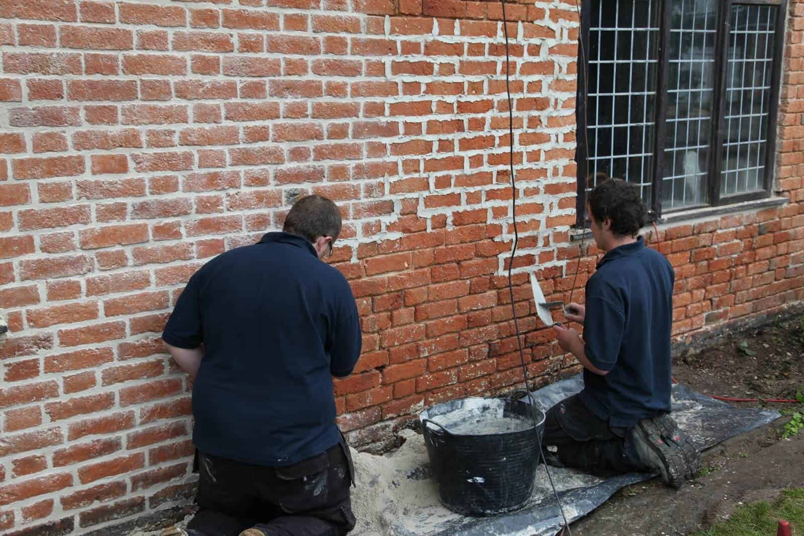 Team members working together on heritage brickwork