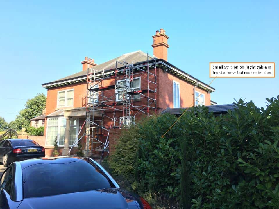 Restoration work on a historic brick church with scaffolding and construction tools.