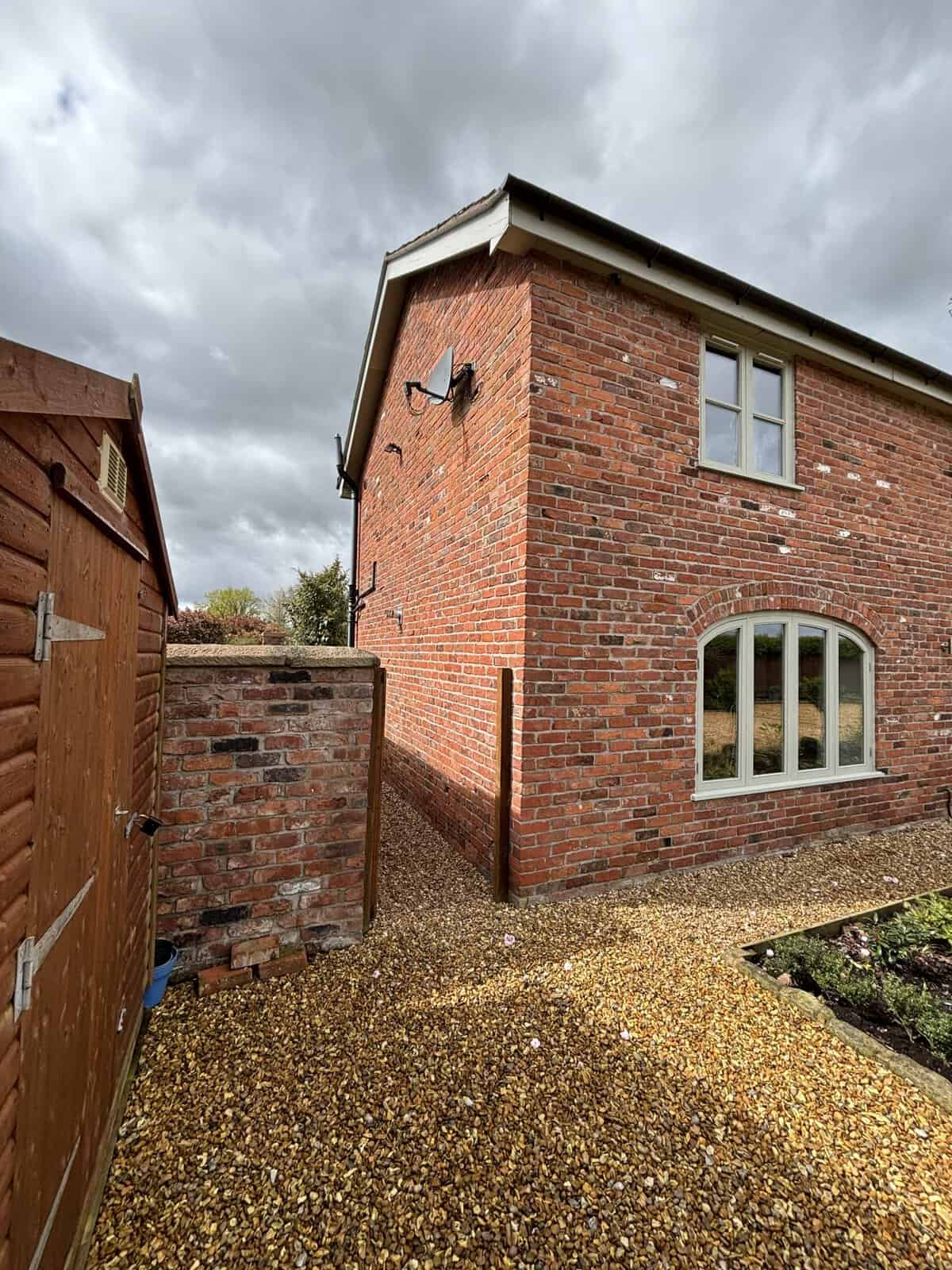 Brick house with arched window and garden path in Brereton, Cheshire.