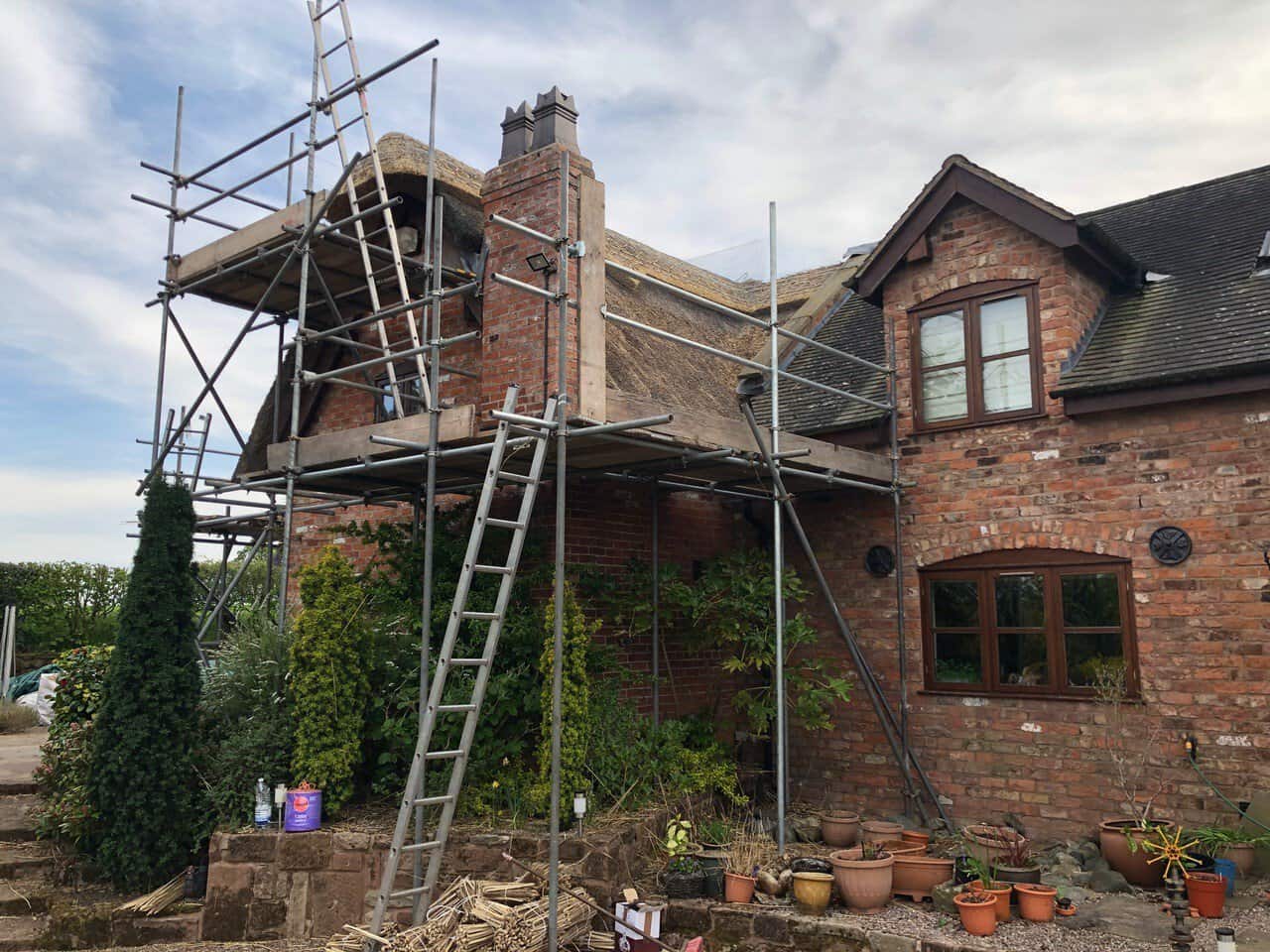 Scaffolding around a brick chimney for repointing work at a residential property.